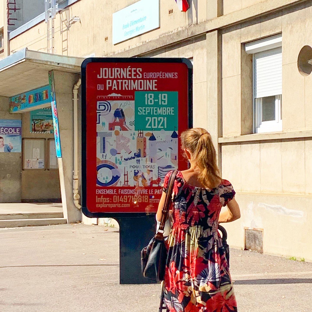 Affiche rouge du patrimoine dans la rue.