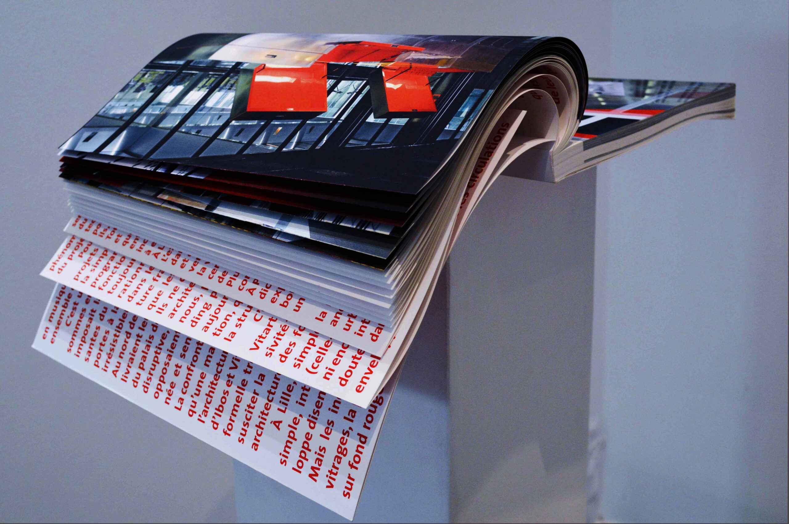 Pages photographiques et texte rouge.
