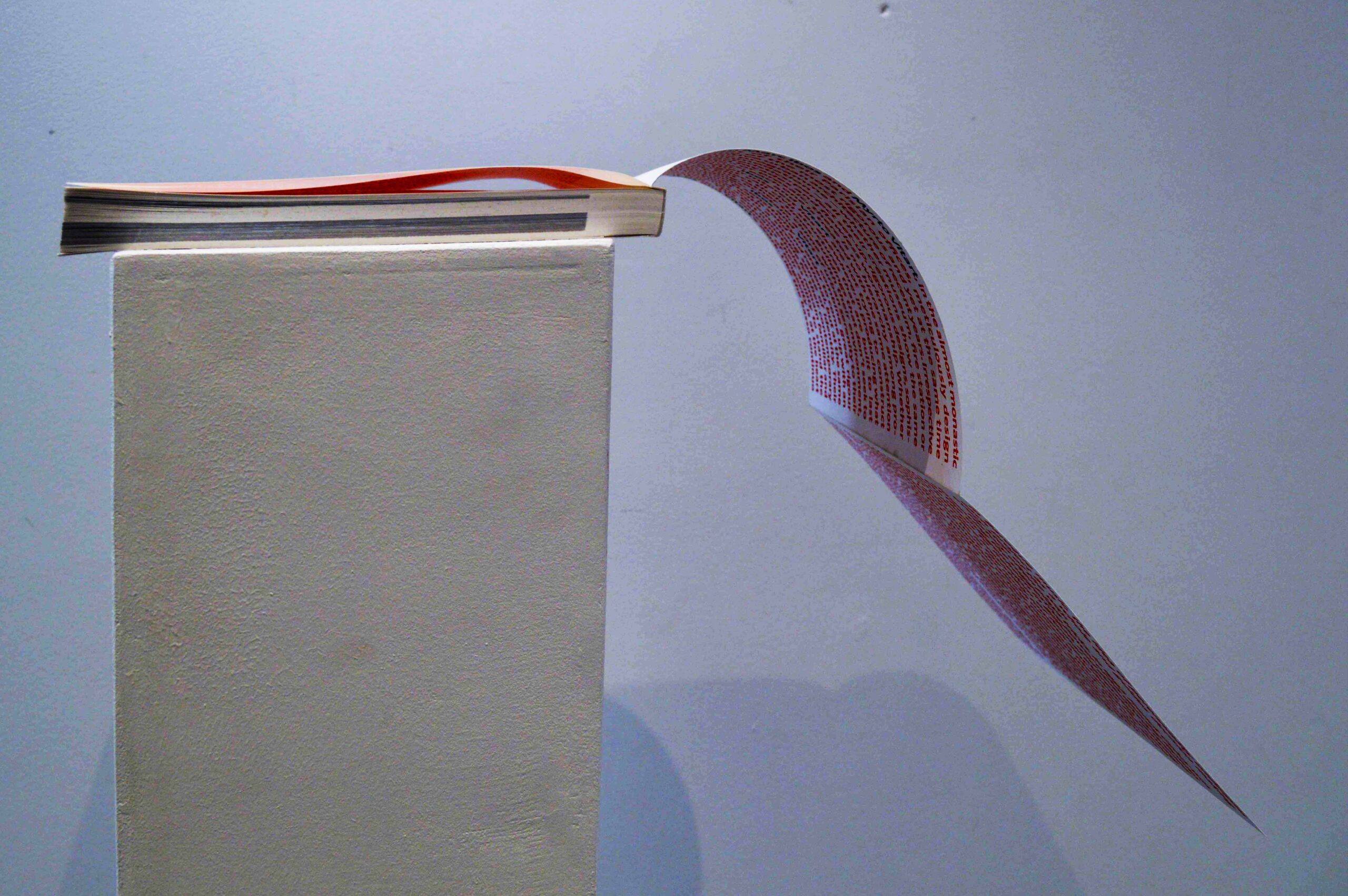 Livre ouvert avec pages pendantes.
