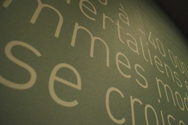 Détail du lettrage clair sur un mur vert.