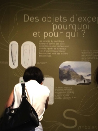 Visiteuse devant un panneau vert.