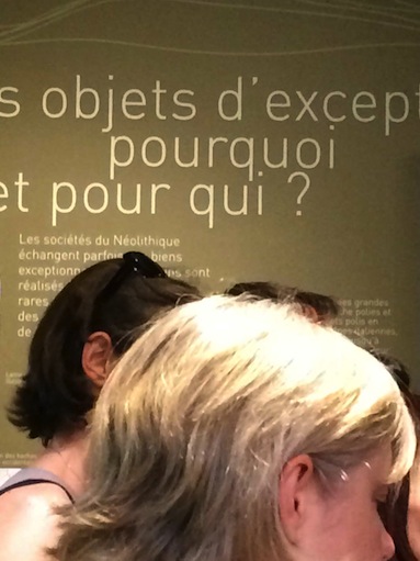 Visiteurs devant un texte mural.