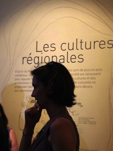 Visiteuse devant le panneau des cultures régionales.
