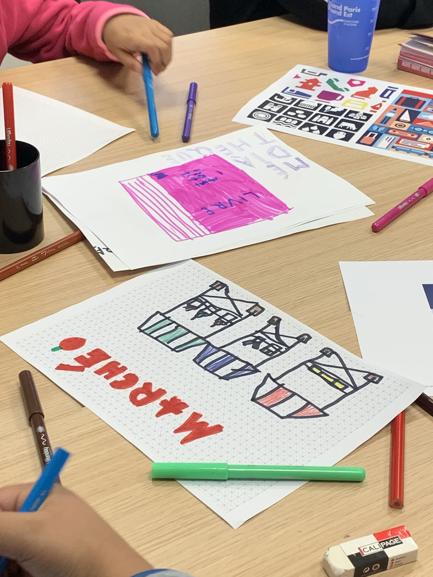 Dessins et crayons sur une table.