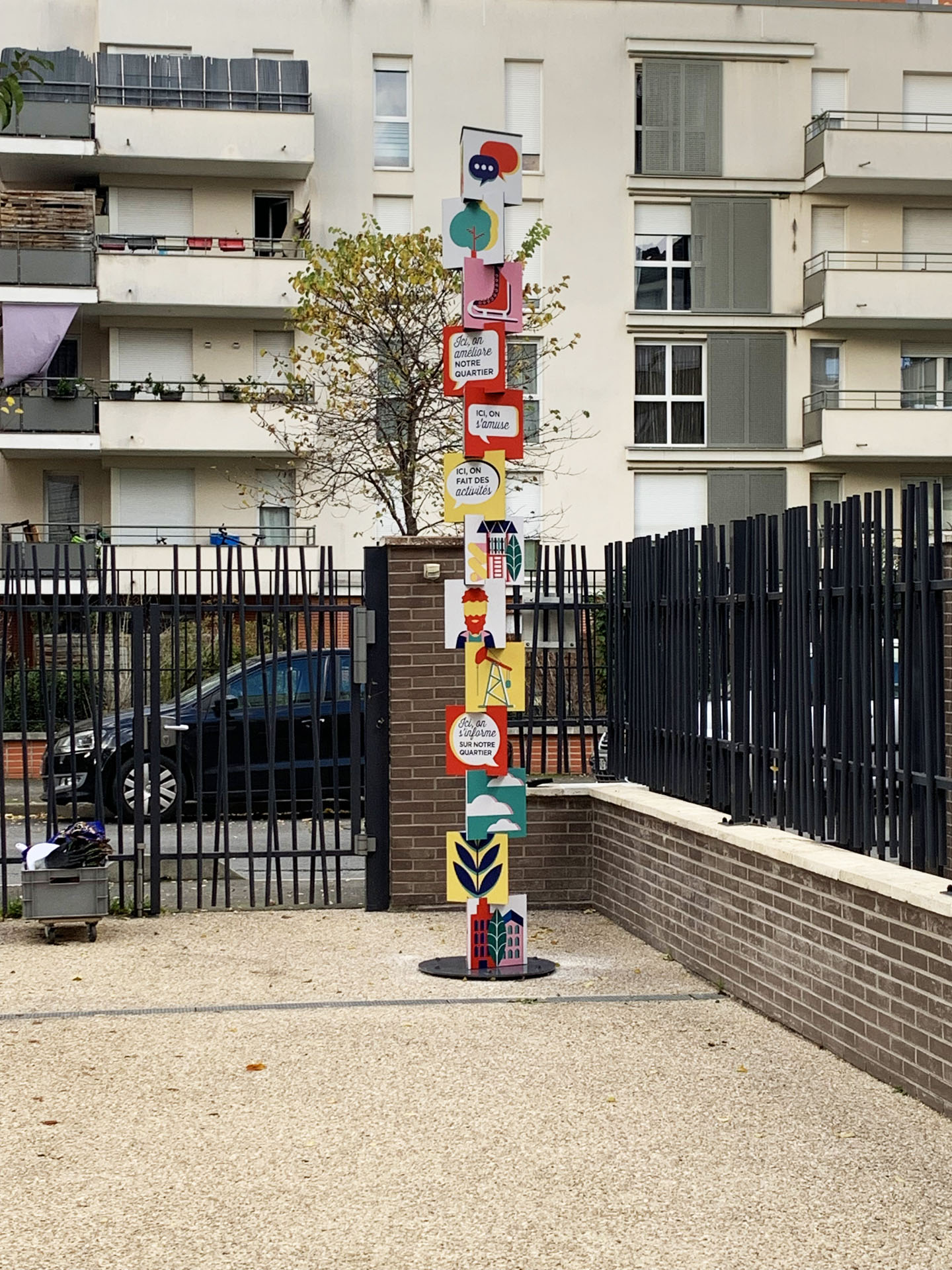 Totem coloré près d'une clôture.