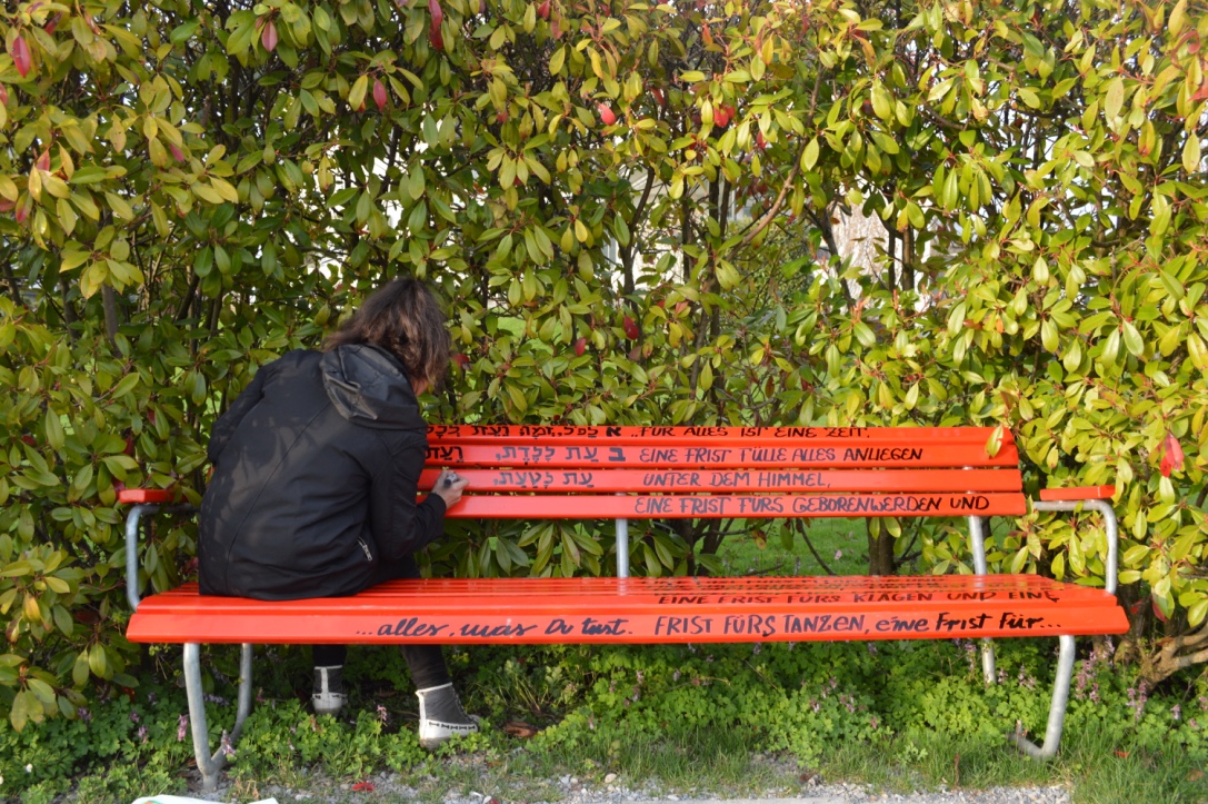 Person sitting on a red bench.