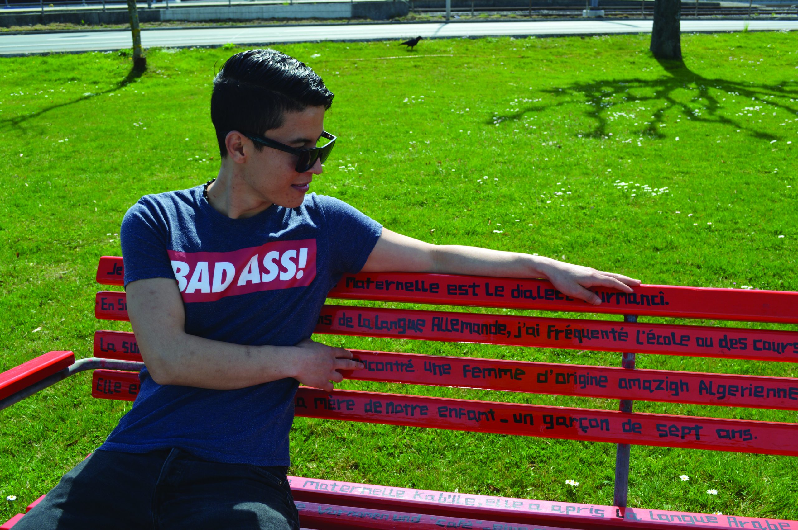 Person sitting on a bench with lettering.