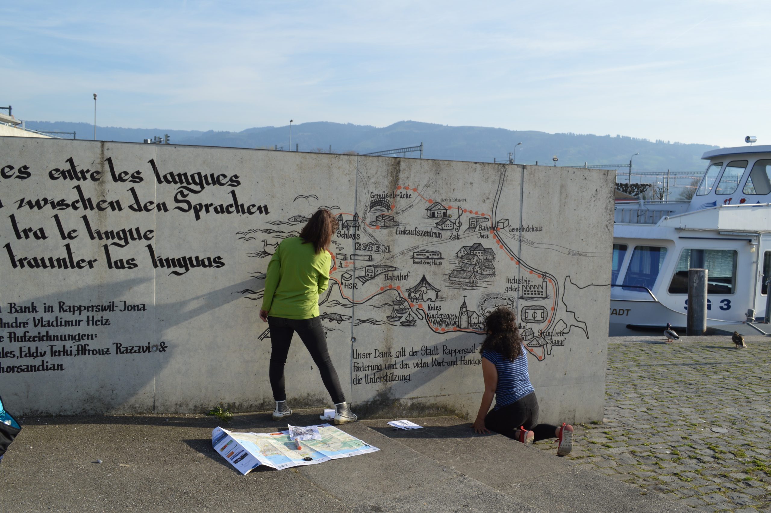 Two people beside a wall map.