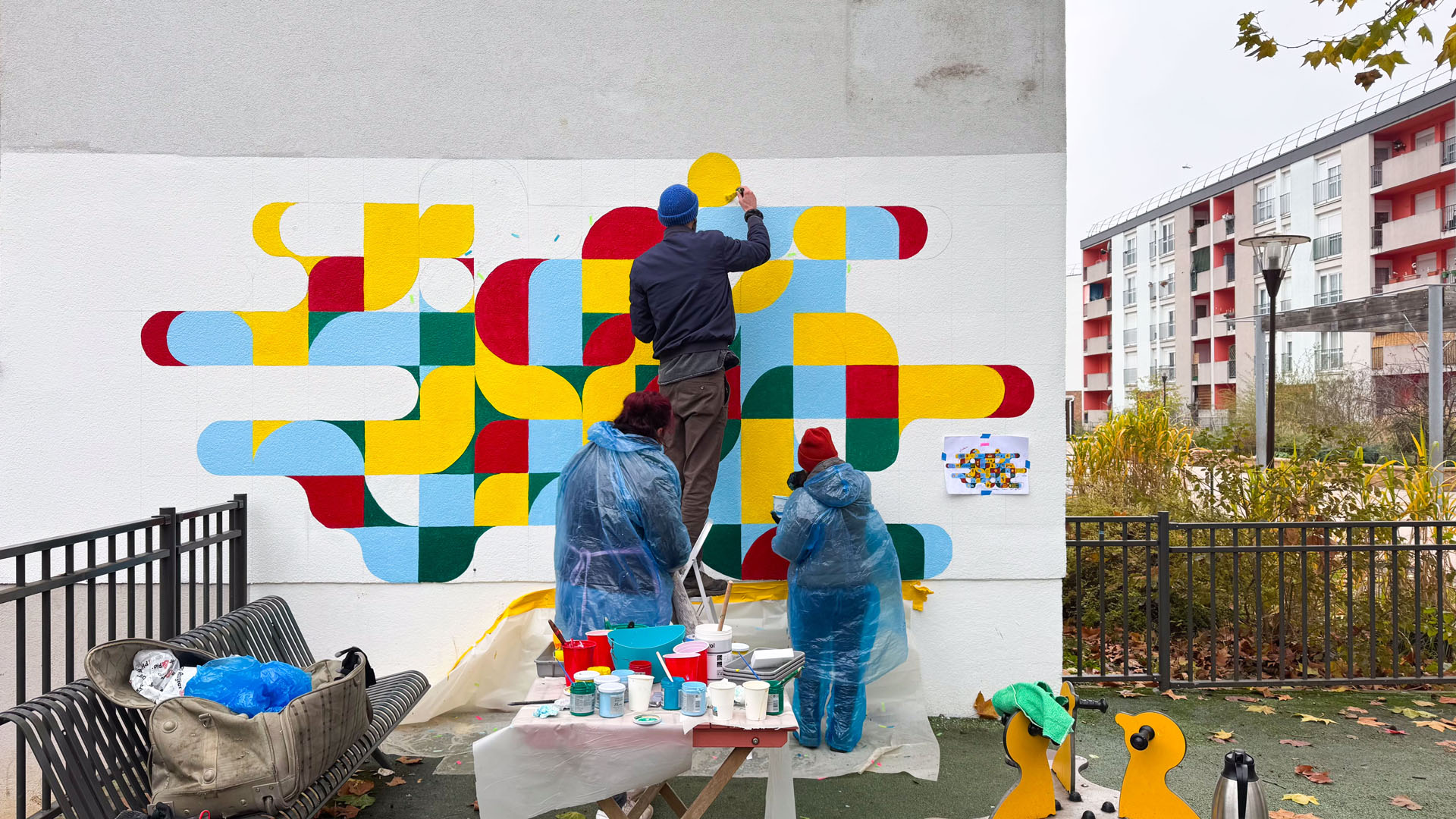 Personnes devant une fresque colorée.