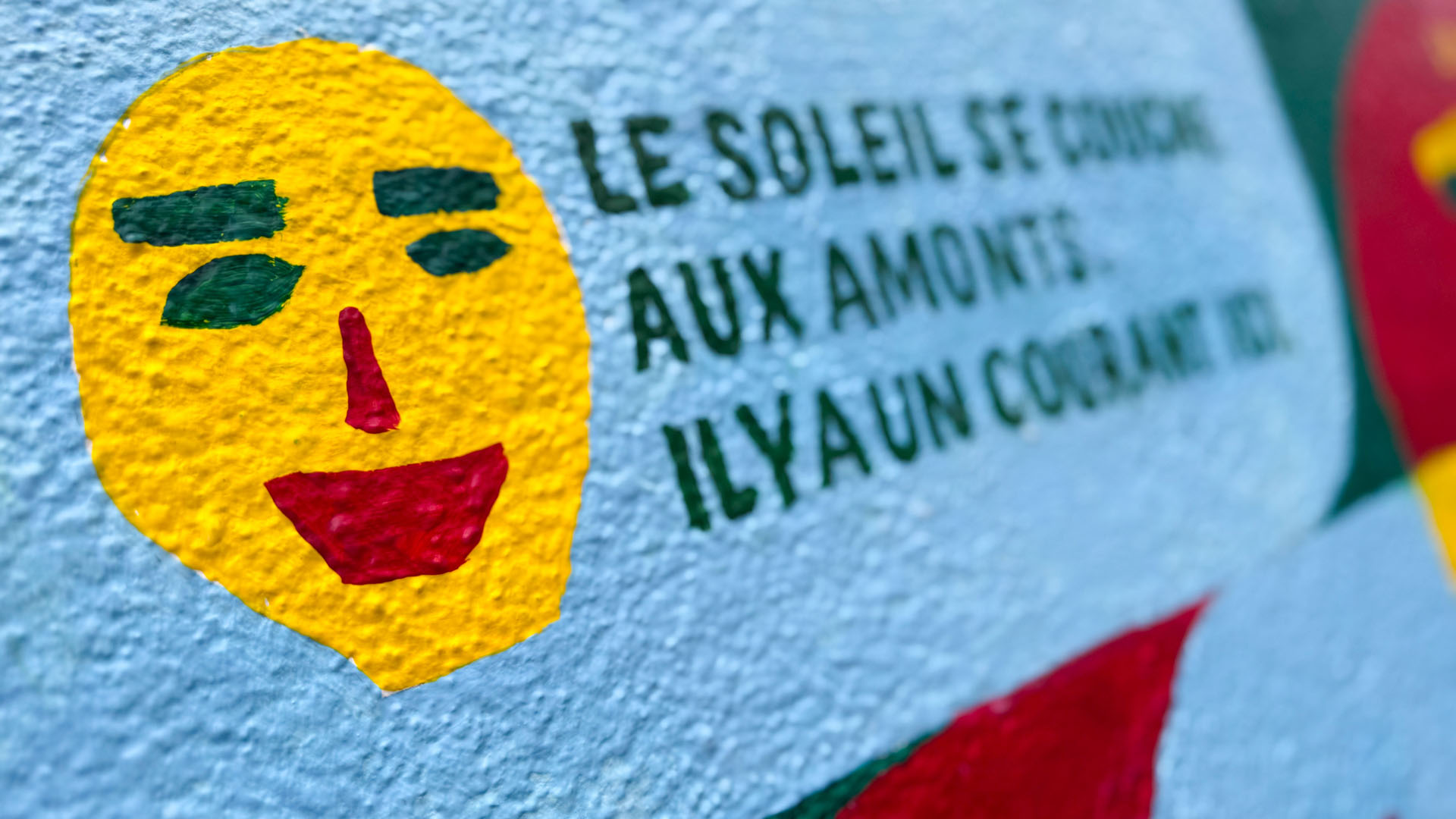 Visage et textes peints sur le mur.
