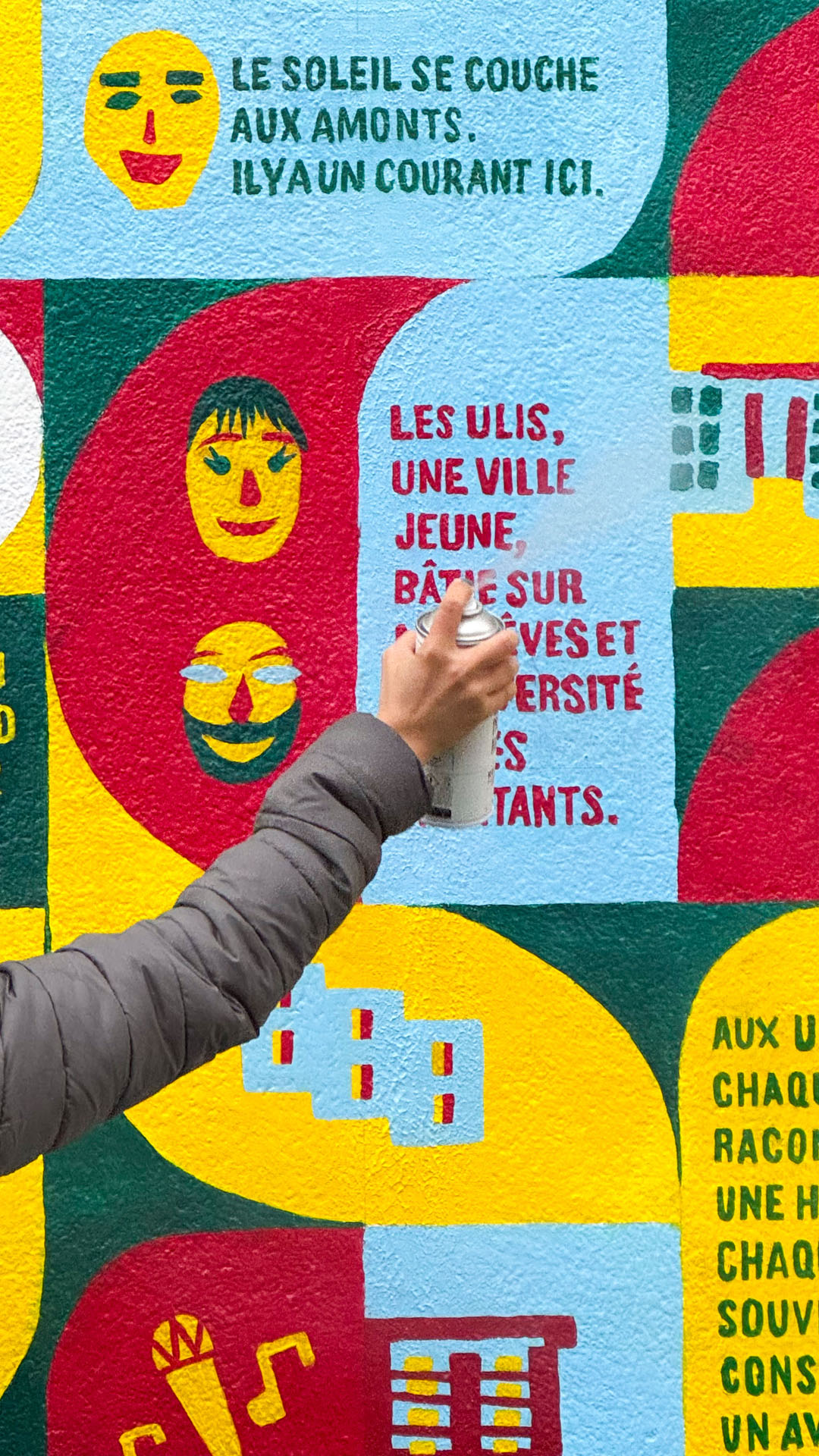Main avec un rouleau devant la fresque.