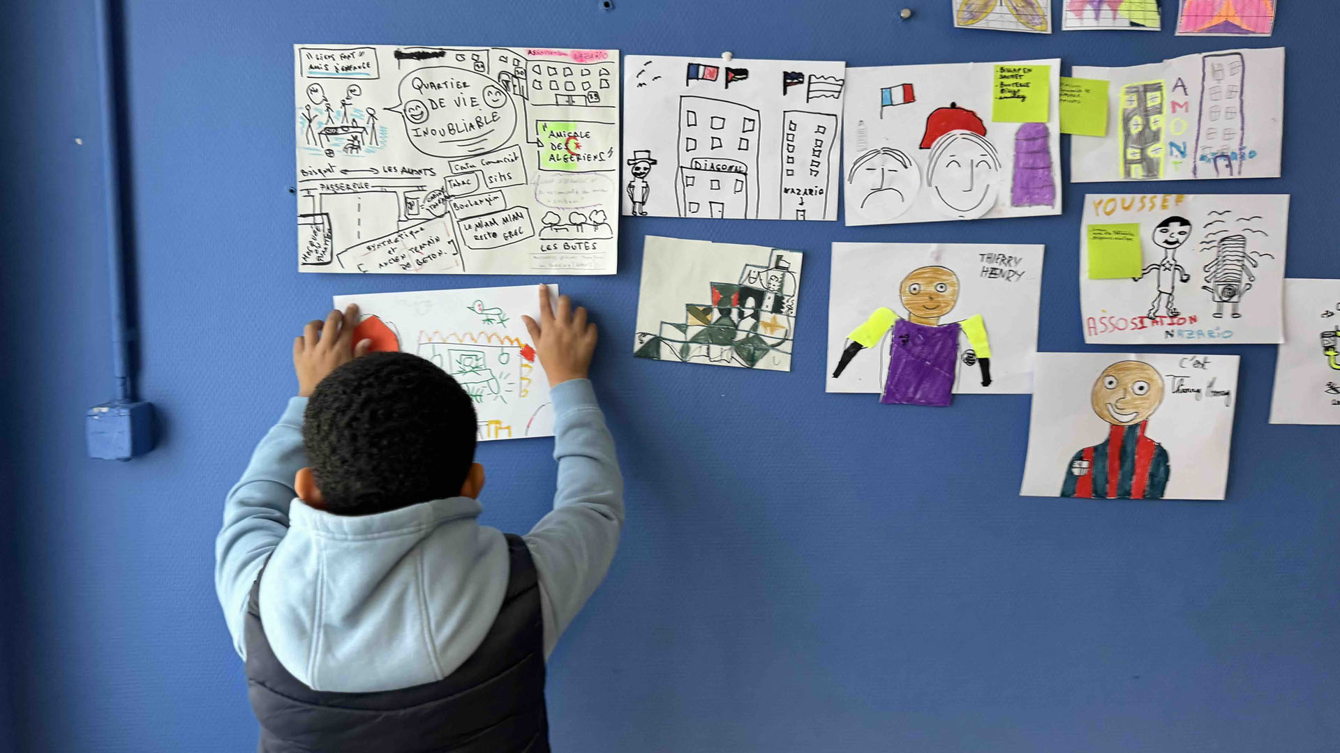 Dessins sur un mur bleu.