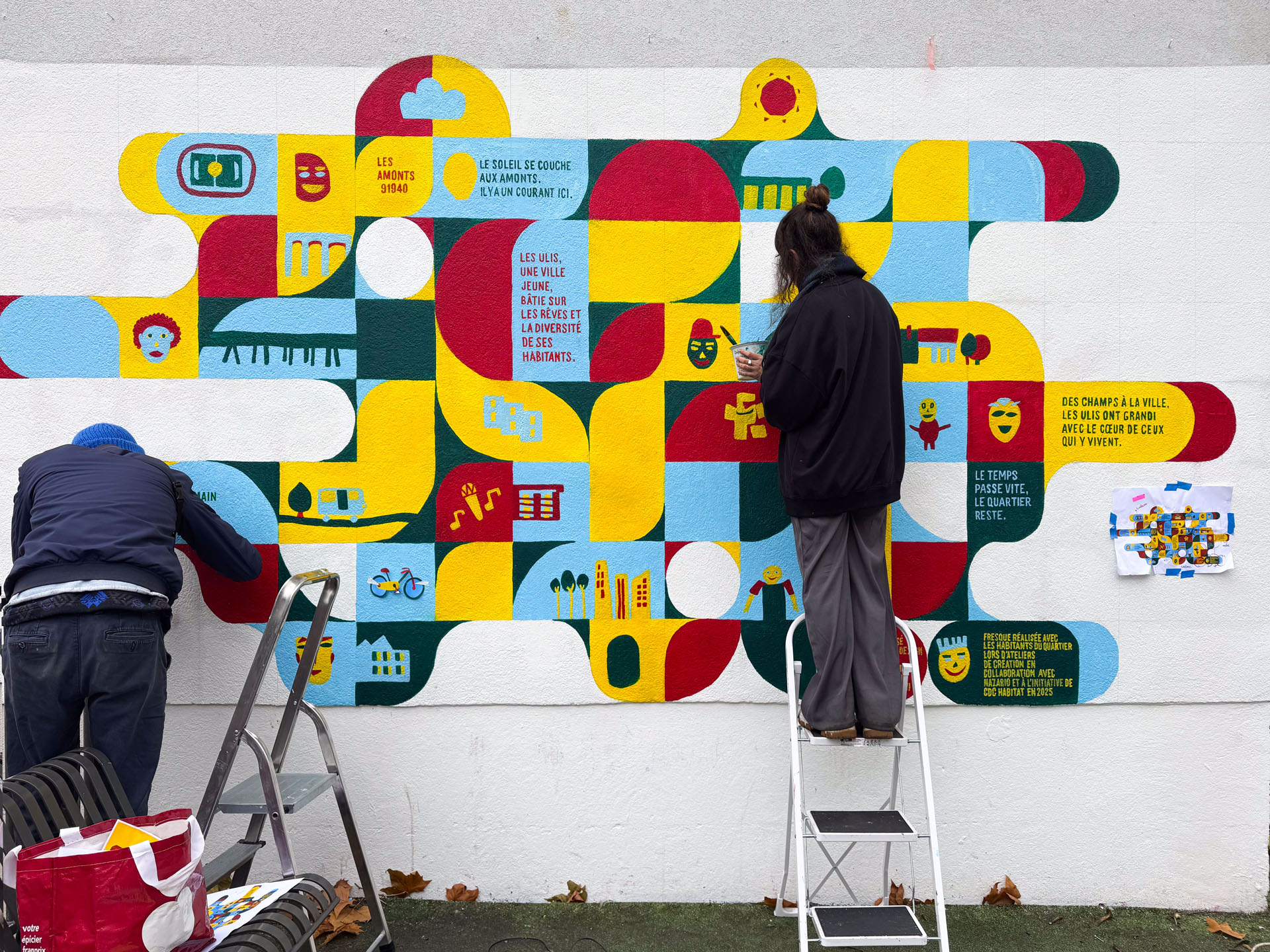 Personnes sur des échelles devant la fresque.