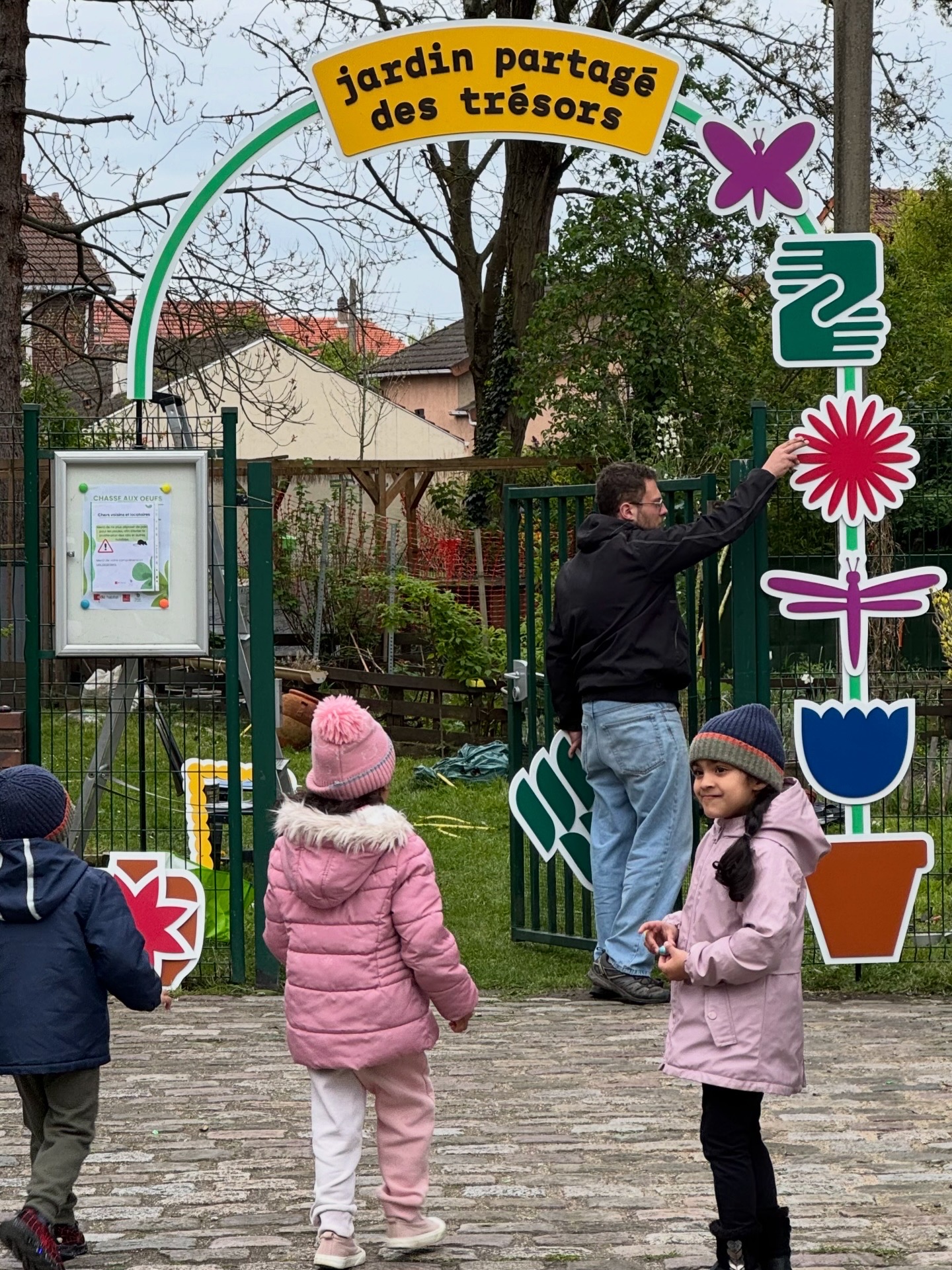 Arche fleurie et personnes à l'entrée du jardin.