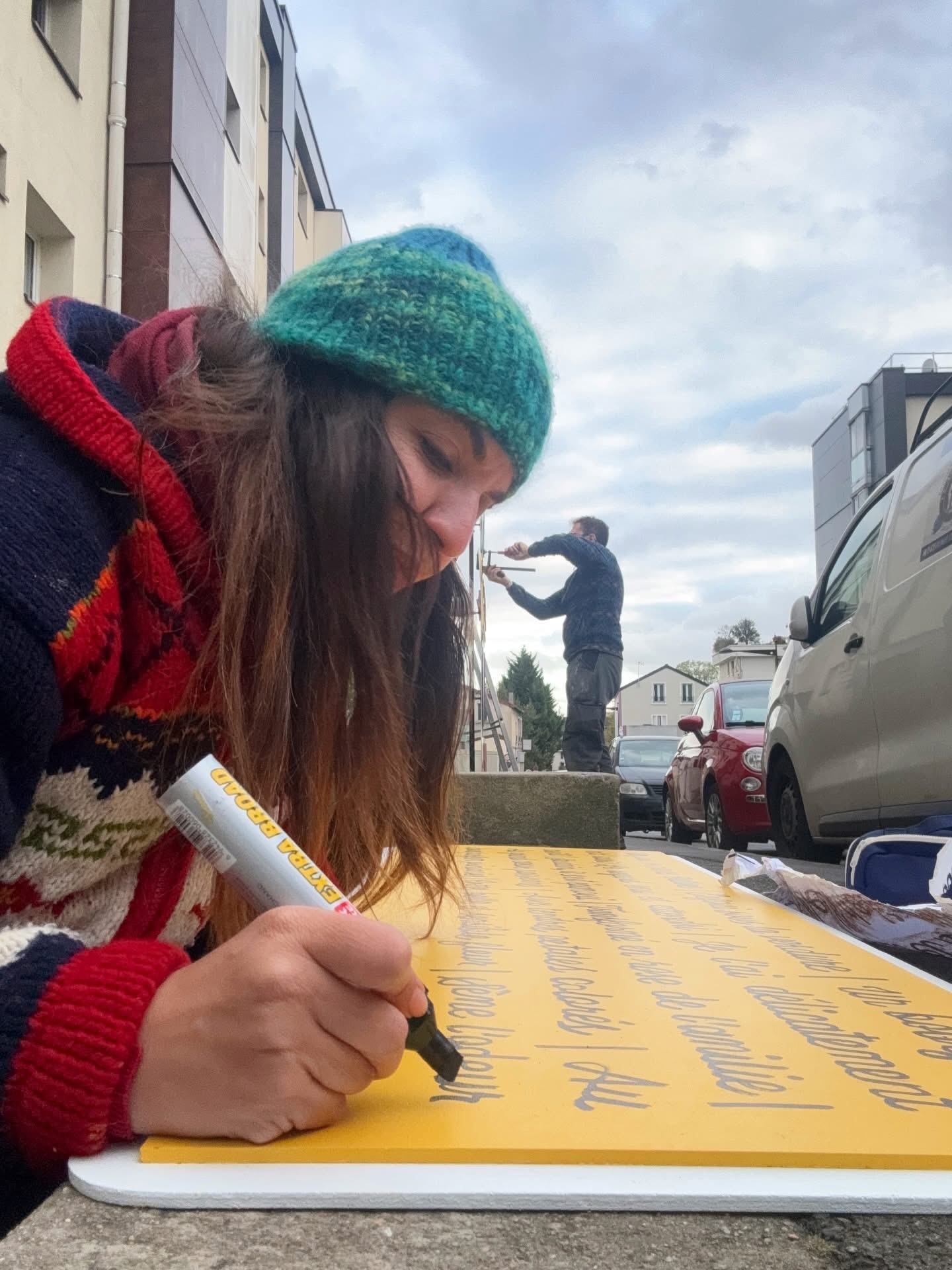 Personne devant un panneau jaune manuscrit.