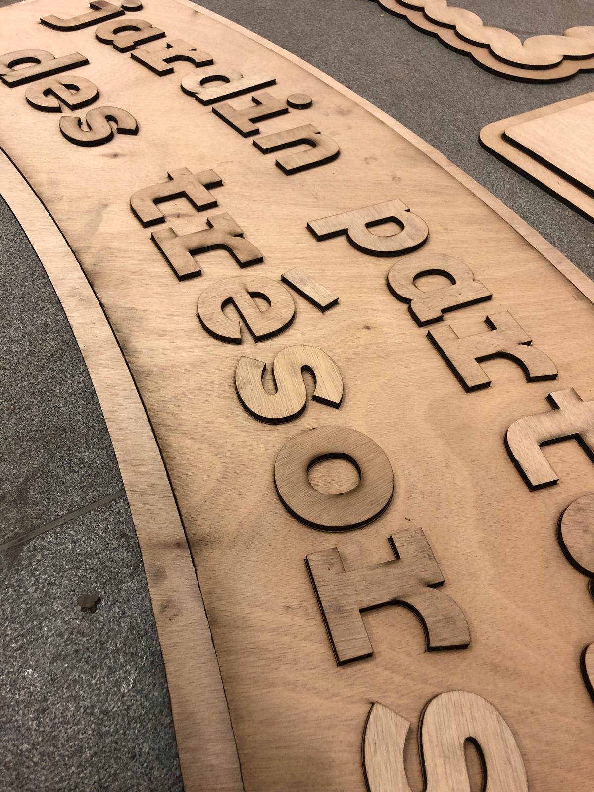 Détail des lettres découpées dans le bois.
